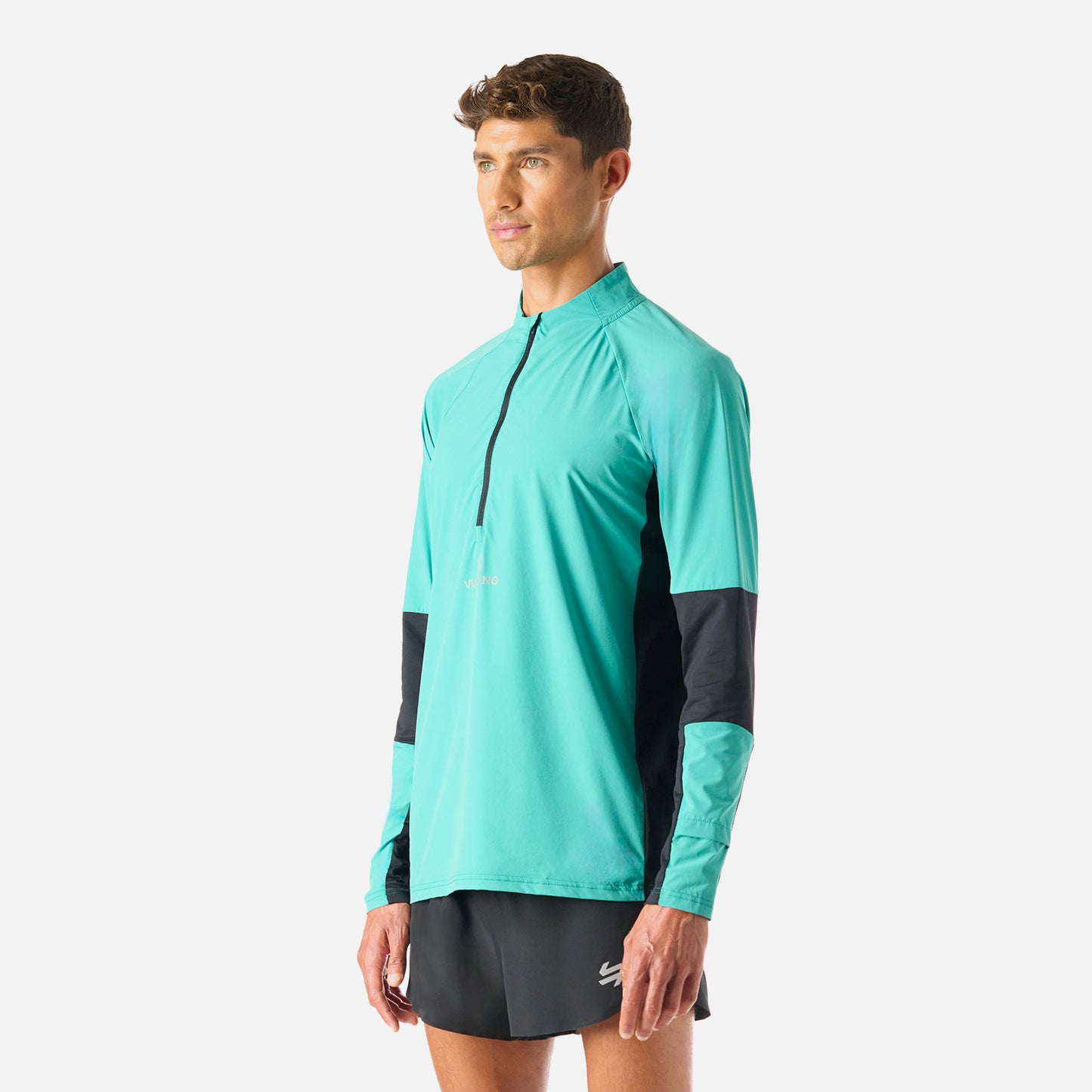 Vista lateral del Polerón Hombre Built To Move Pro 1/4 Zip Midlayer Turquesa Vulcano, diseño ergonómico y tecnología Q-Dry para alto rendimiento.