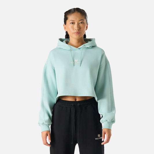 Polerón Mujer Cool Down Sweatshirt Hoody Jade Vulcano con diseño crop, capucha ajustable y logo bordado, ideal para invierno y estilo lifestyle.