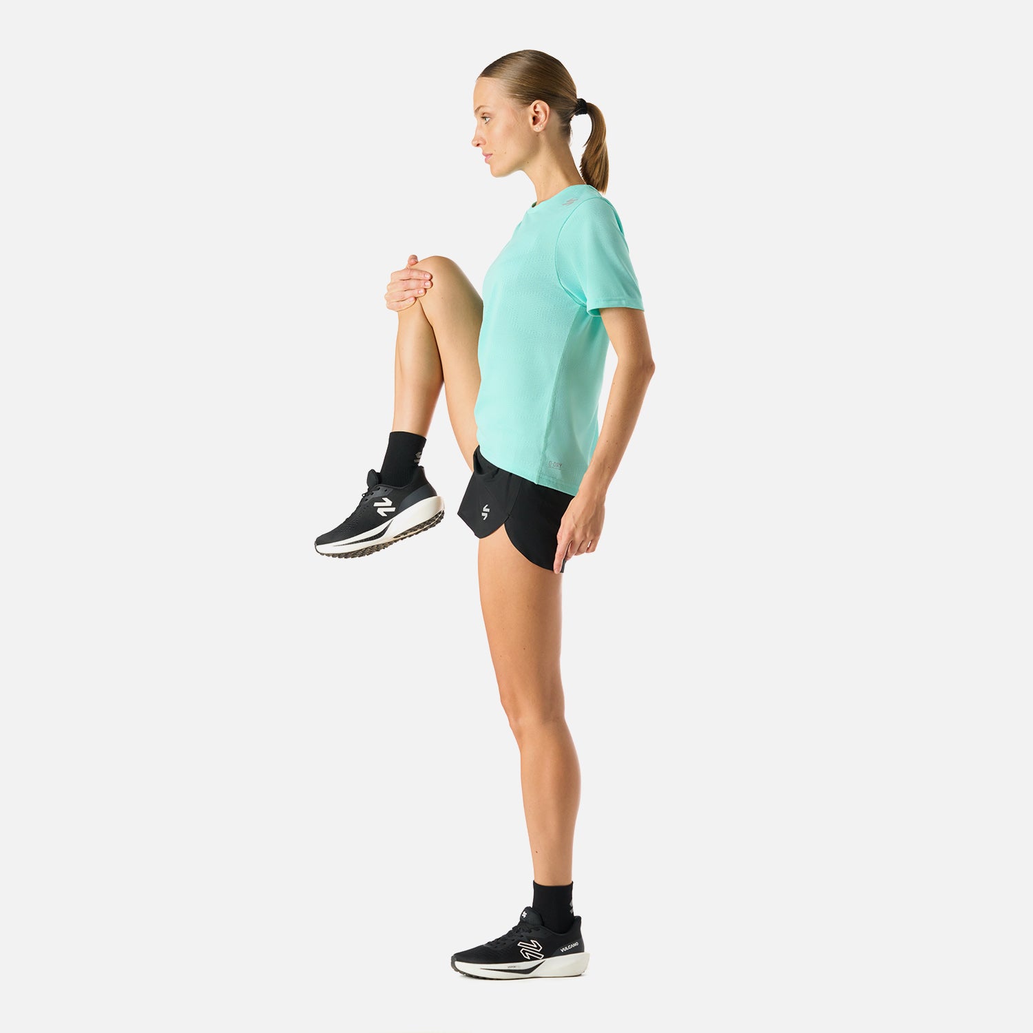 Polera Mujer Built To Move T-Shirt Jade Vulcano en uso durante estiramiento. Tejido técnico que favorece la movilidad y frescura.