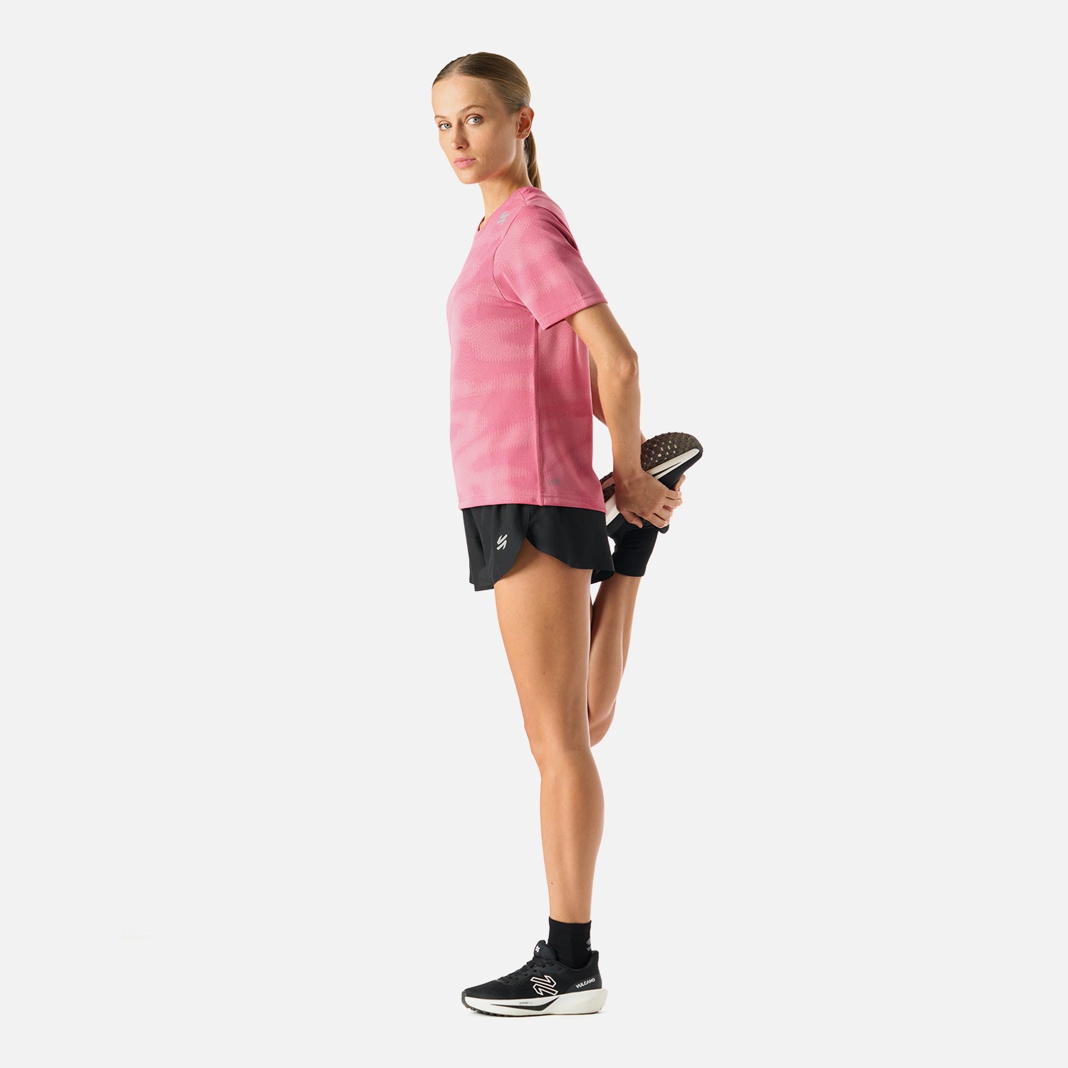 Polera Mujer Built To Move T-Shirt Rosado Vulcano en uso durante estiramiento. Tejido técnico que favorece la movilidad y frescura.