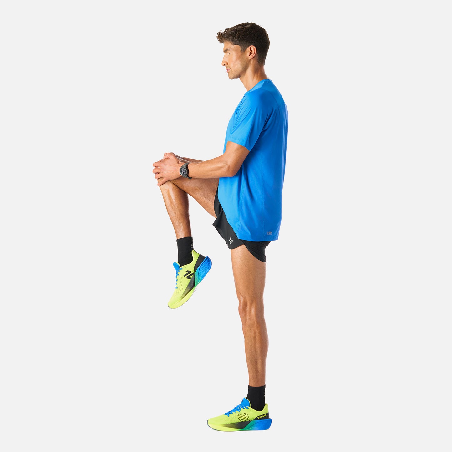 Polera Hombre Azul Vulcano - Deportiva Q-Dry, en uso durante estiramiento. Prenda funcional para deportes como running o pádel.