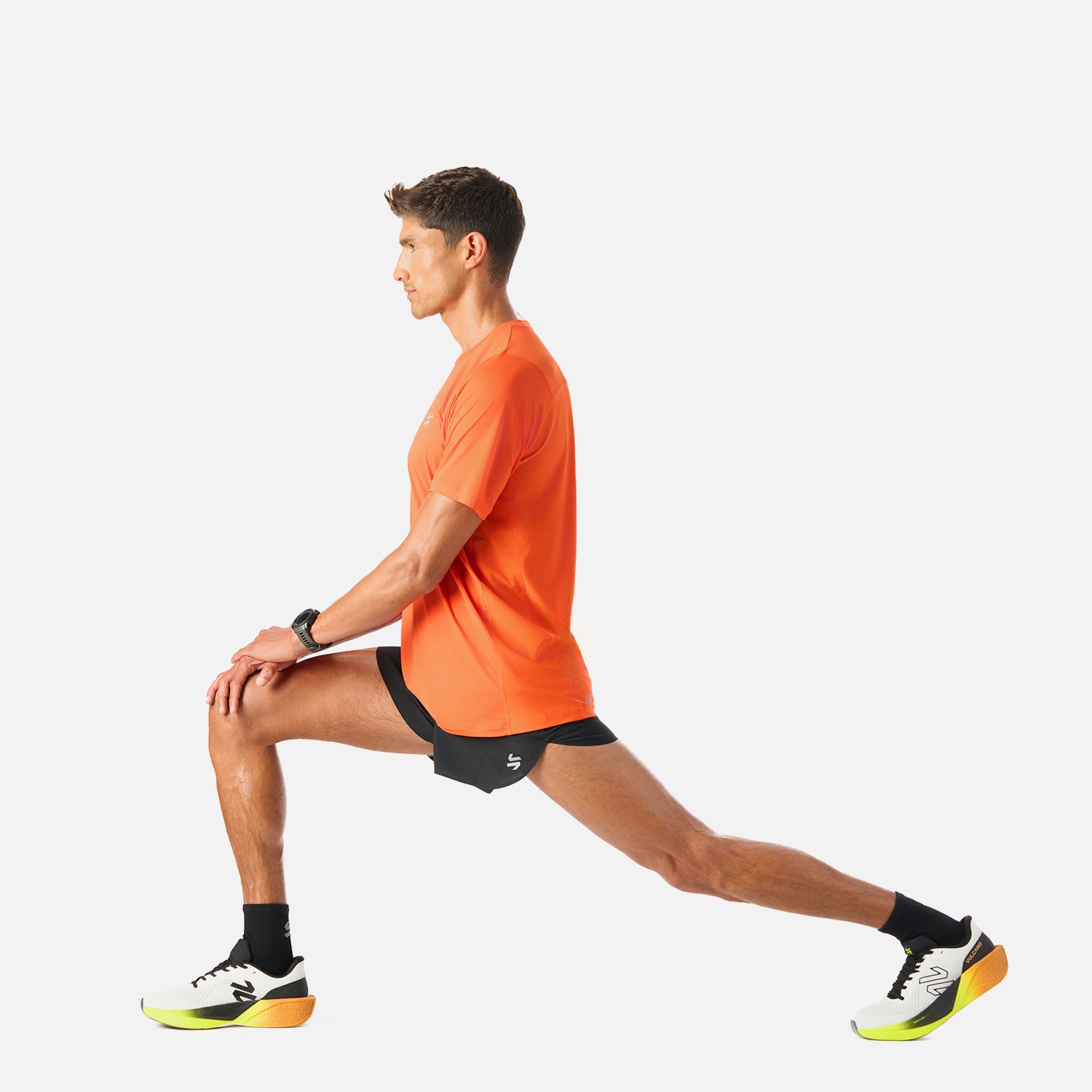 Polera Hombre Naranjo Vulcano - Deportiva Q-Dry, en uso durante estiramiento. Prenda funcional para deportes como running o pádel.