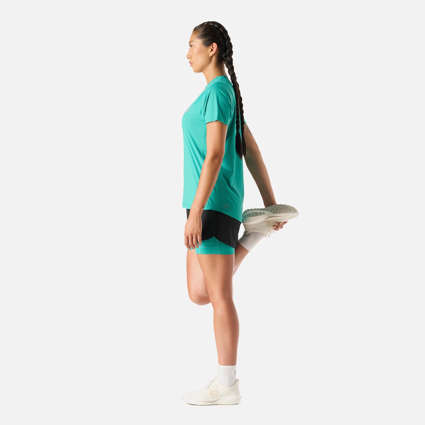 Polera Mujer Built To Move T-Shirt Turquesa Vulcano en uso durante estiramiento. Tejido técnico que favorece la movilidad y frescura.