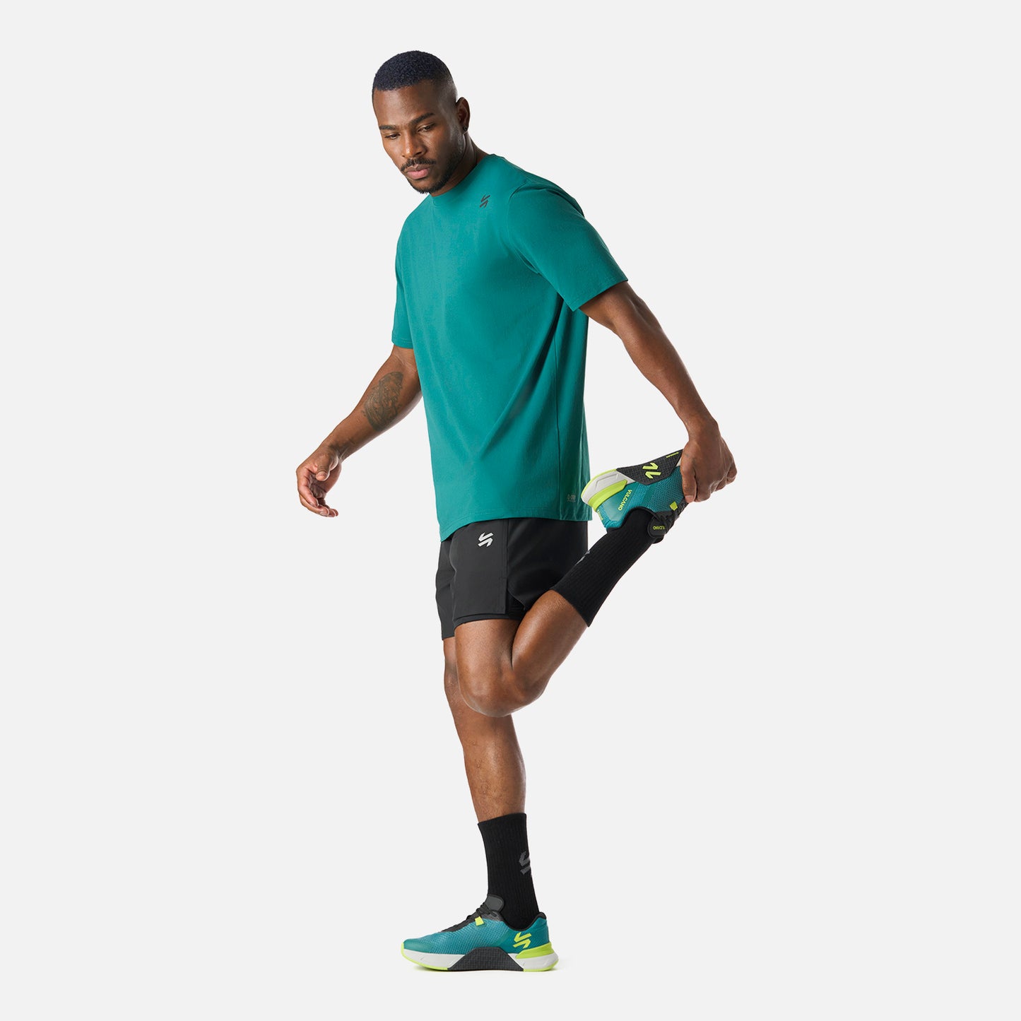 Polera Hombre Tempo T-Shirt Petroleo Vulcano combinada con short negro, perfecta para rutinas de entrenamiento gracias a su comodidad y frescura.