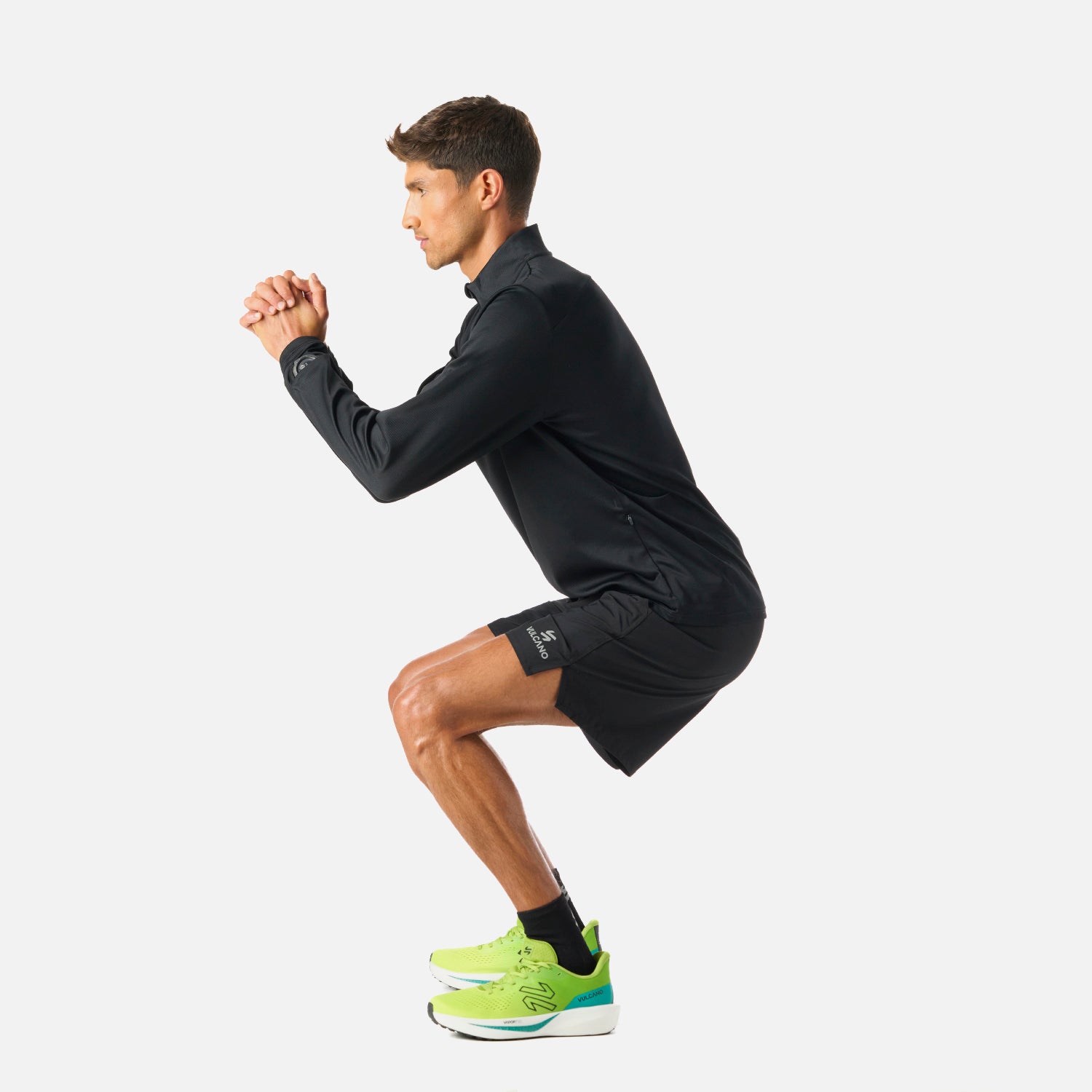Polerón Hombre Built To Move 1/4 Zip Midlayer Negro Vulcano en uso durante sentadilla, demostrando su flexibilidad y comodidad para entrenamiento funcional.
