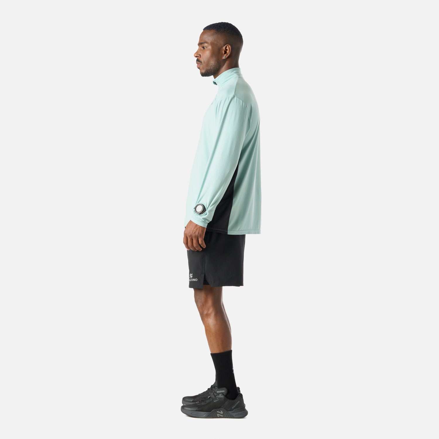 Vista lateral del Polerón Hombre Tempo 1/4 Zip Midlayer Jade Vulcano mostrando su corte ergonómico y tejido técnico para entrenamiento deportivo.