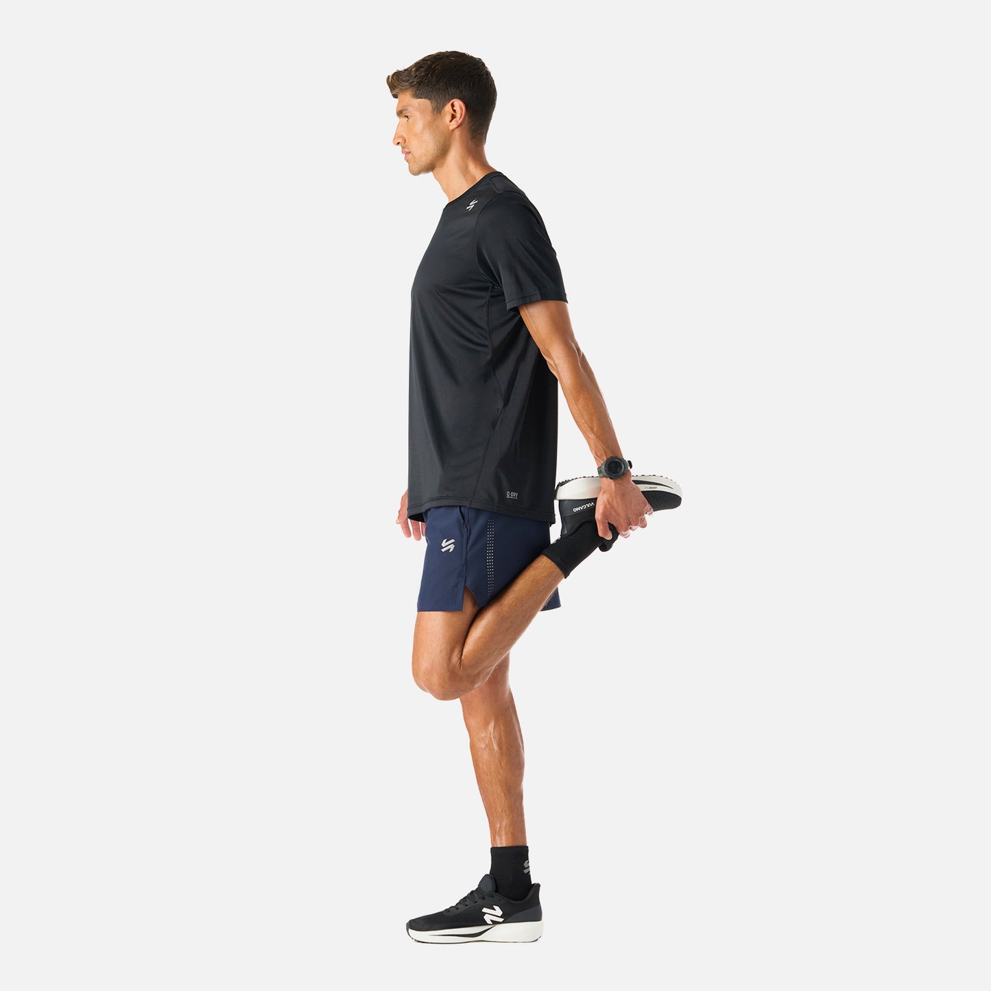 Shorts Tempo 5'' Hombre Vulcano en uso durante estiramiento, mostrando su flexibilidad y libertad de movimiento para actividades deportivas.