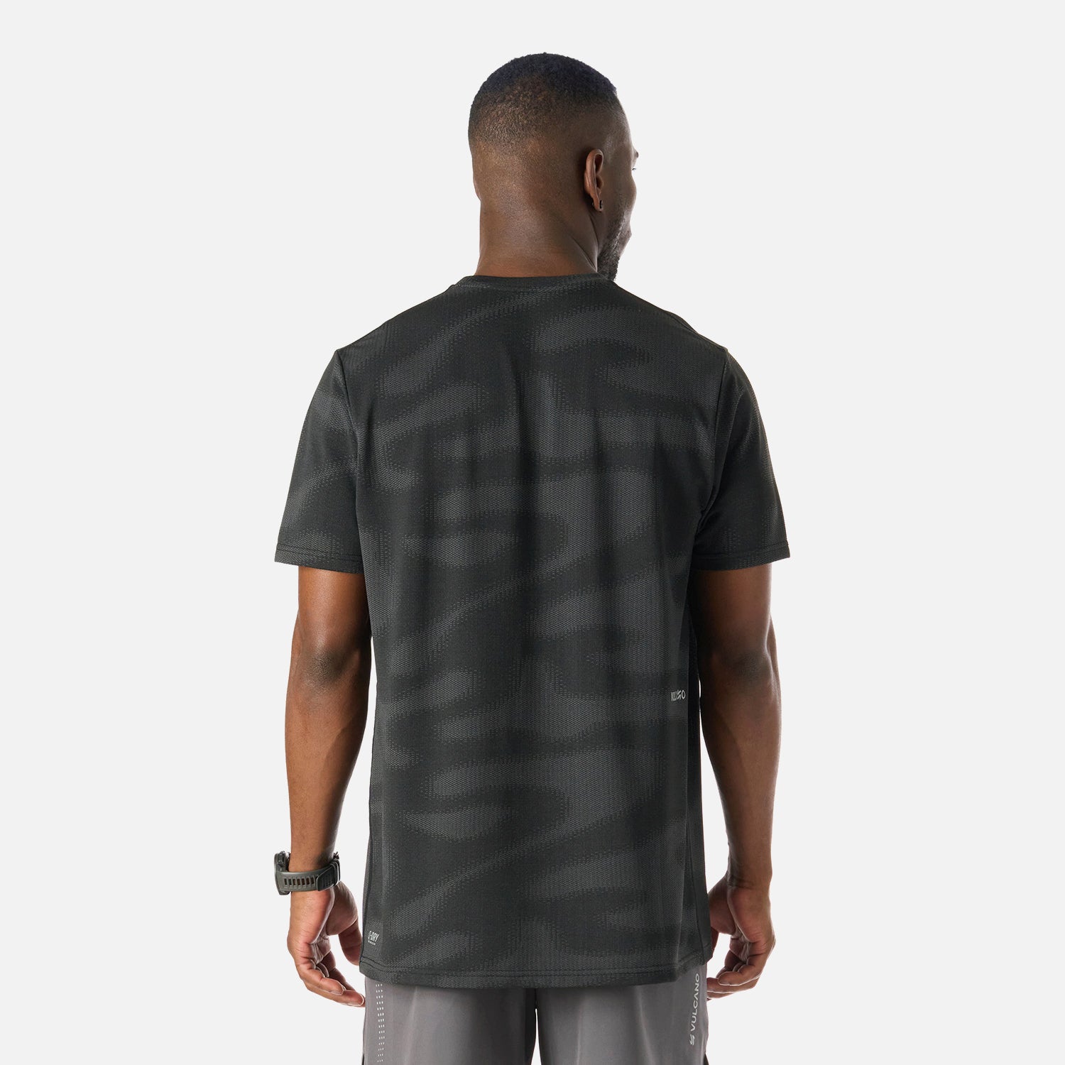Vista trasera de la Polera Hombre Built To Move Pro T-Shirt Negro Vulcano, con patrón texturizado y ajuste relajado para mayor comodidad.