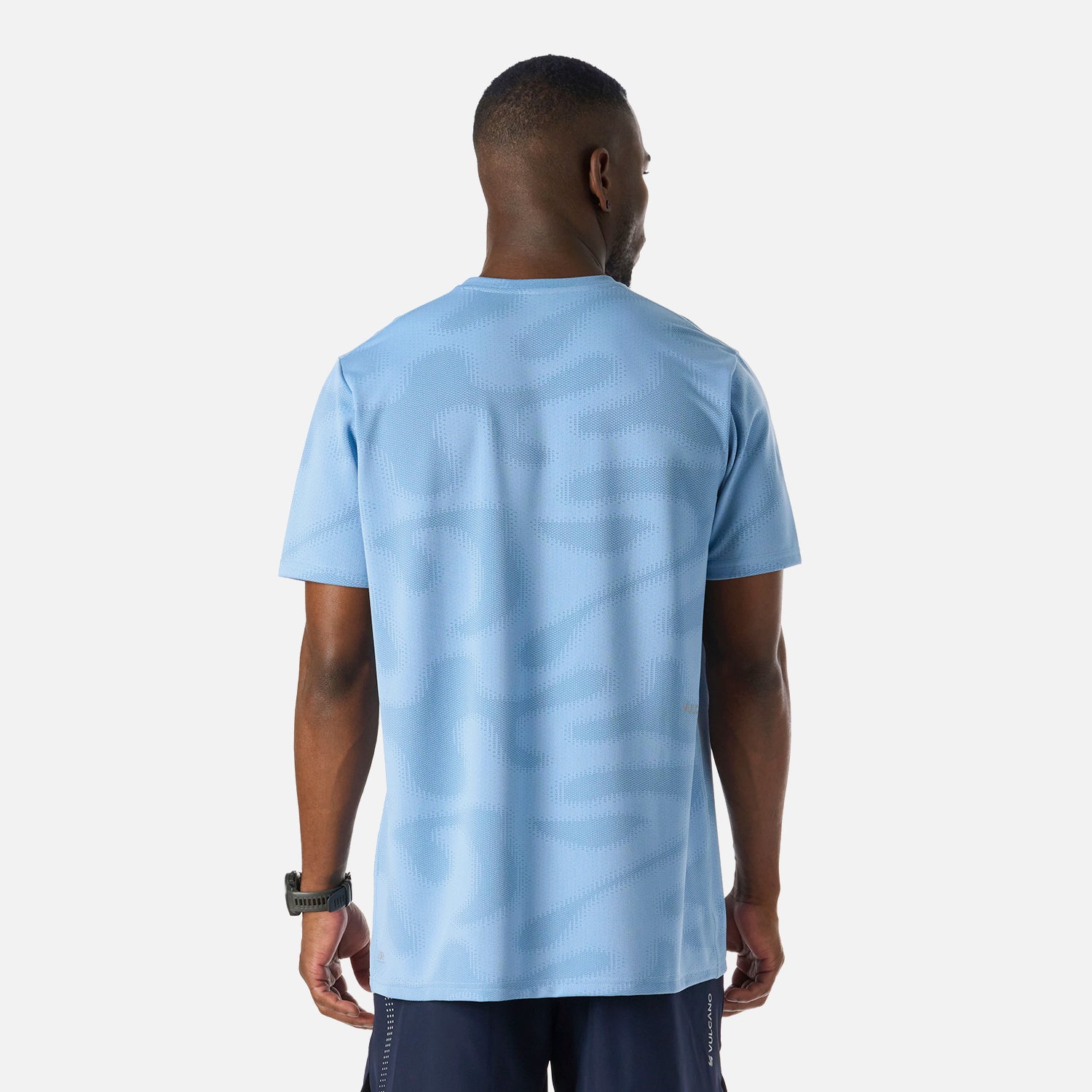 Vista trasera de la Polera Hombre Built To Move Pro T-Shirt Celeste Vulcano, con patrón texturizado y ajuste relajado para mayor comodidad.