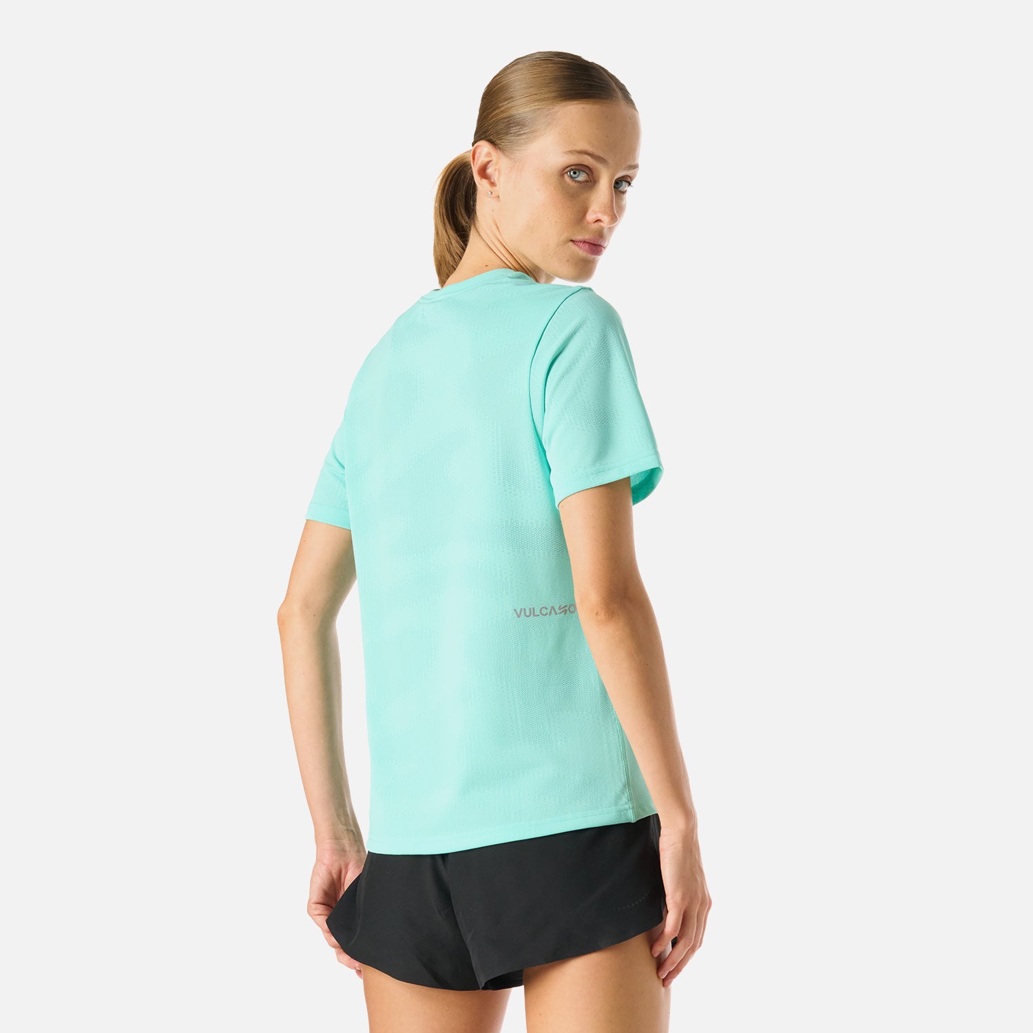 Vista trasera de la Polera Mujer Built To Move T-Shirt Jade Vulcano, mostrando paneles de ventilación y ajuste anatómico.