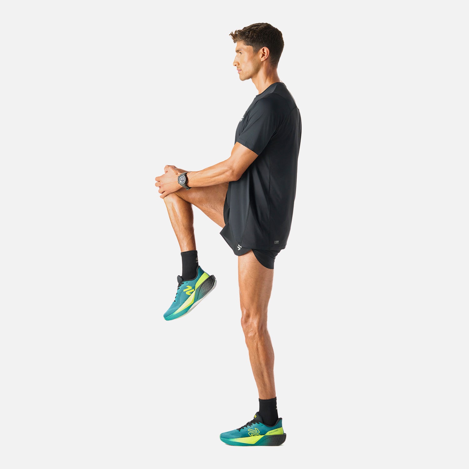 Polera Hombre Negro Vulcano - Deportiva Q-Dry, en uso durante estiramiento. Prenda funcional para deportes como running o pádel.