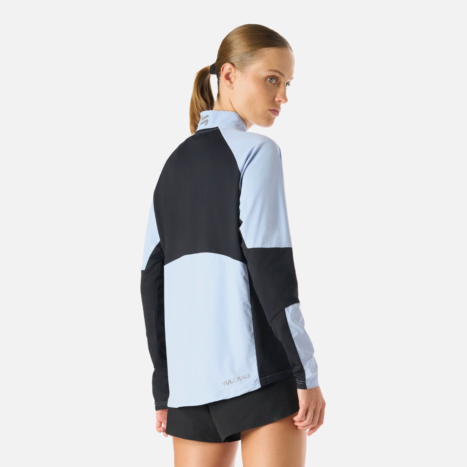 Parte trasera del Polerón Mujer Built To Move Pro 1/4 Zip Midlayer Celeste Vulcano con panel negro, diseñado para máxima movilidad y protección.