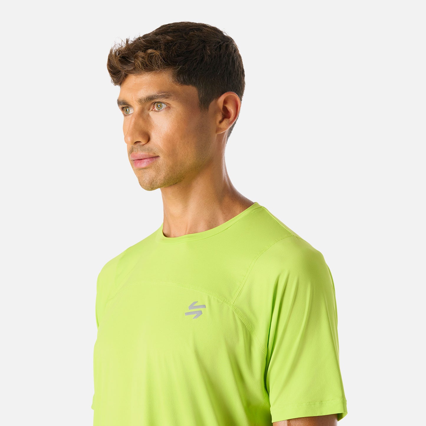 Polera Hombre Verde Lima Vulcano - Deportiva Q-Dry, detalle del logo frontal. Estilo moderno con ajuste cómodo para actividades deportivas.