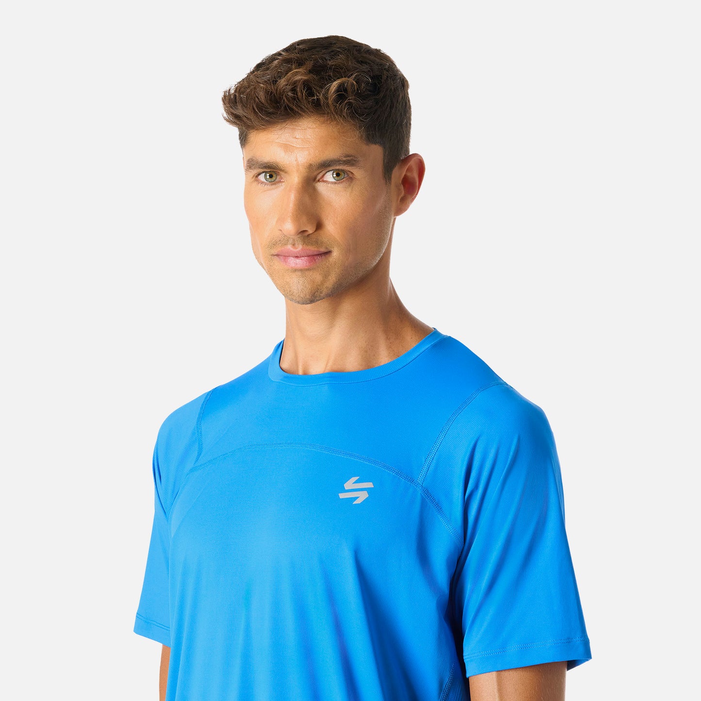 Polera Hombre Azul Vulcano - Deportiva Q-Dry, detalle del logo frontal. Estilo moderno con ajuste cómodo para actividades deportivas.