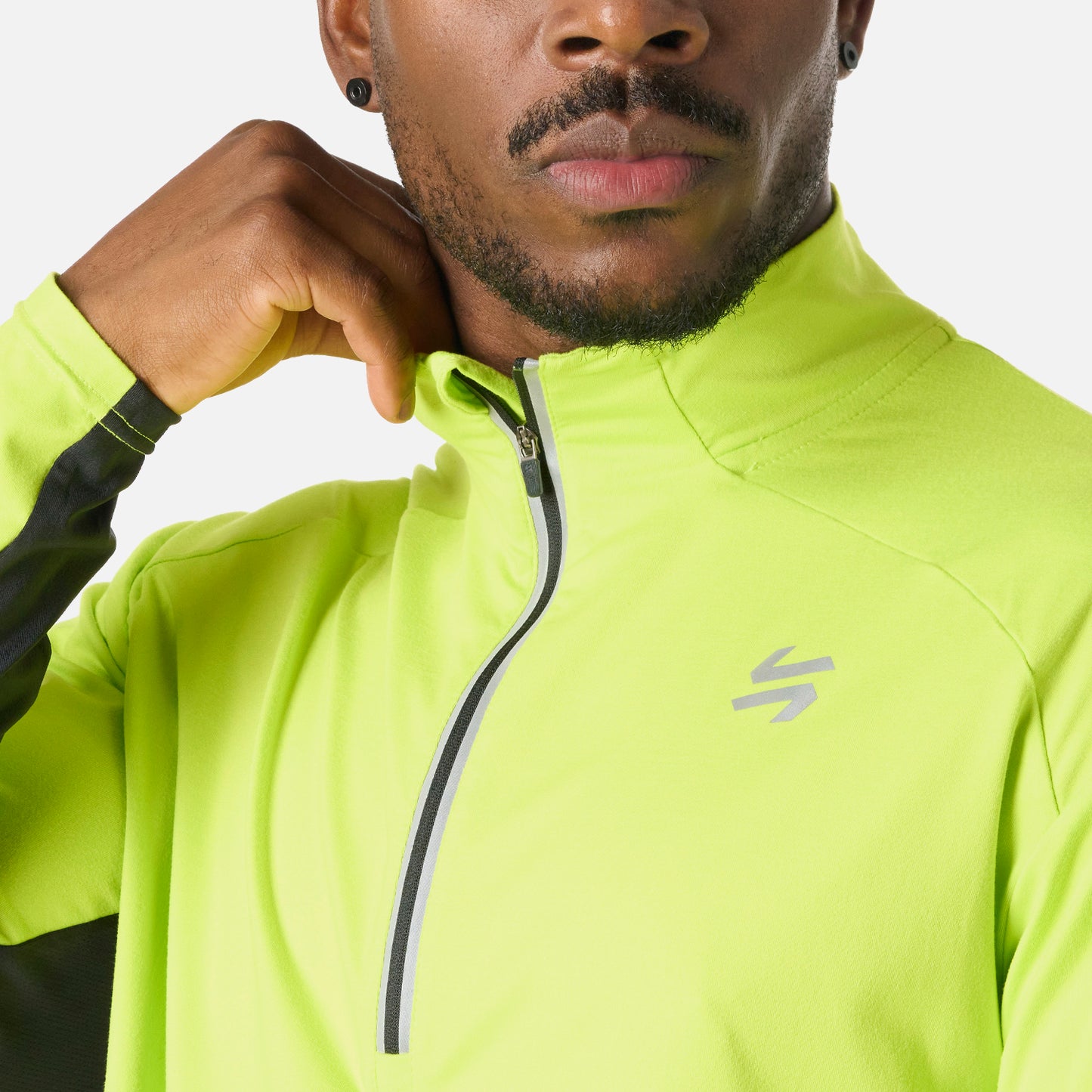 Detalle del cierre y logo en el pecho del Polerón Hombre Tempo 1/4 Zip Midlayer Verde Lima Vulcano, con tela técnica Q-Dry.