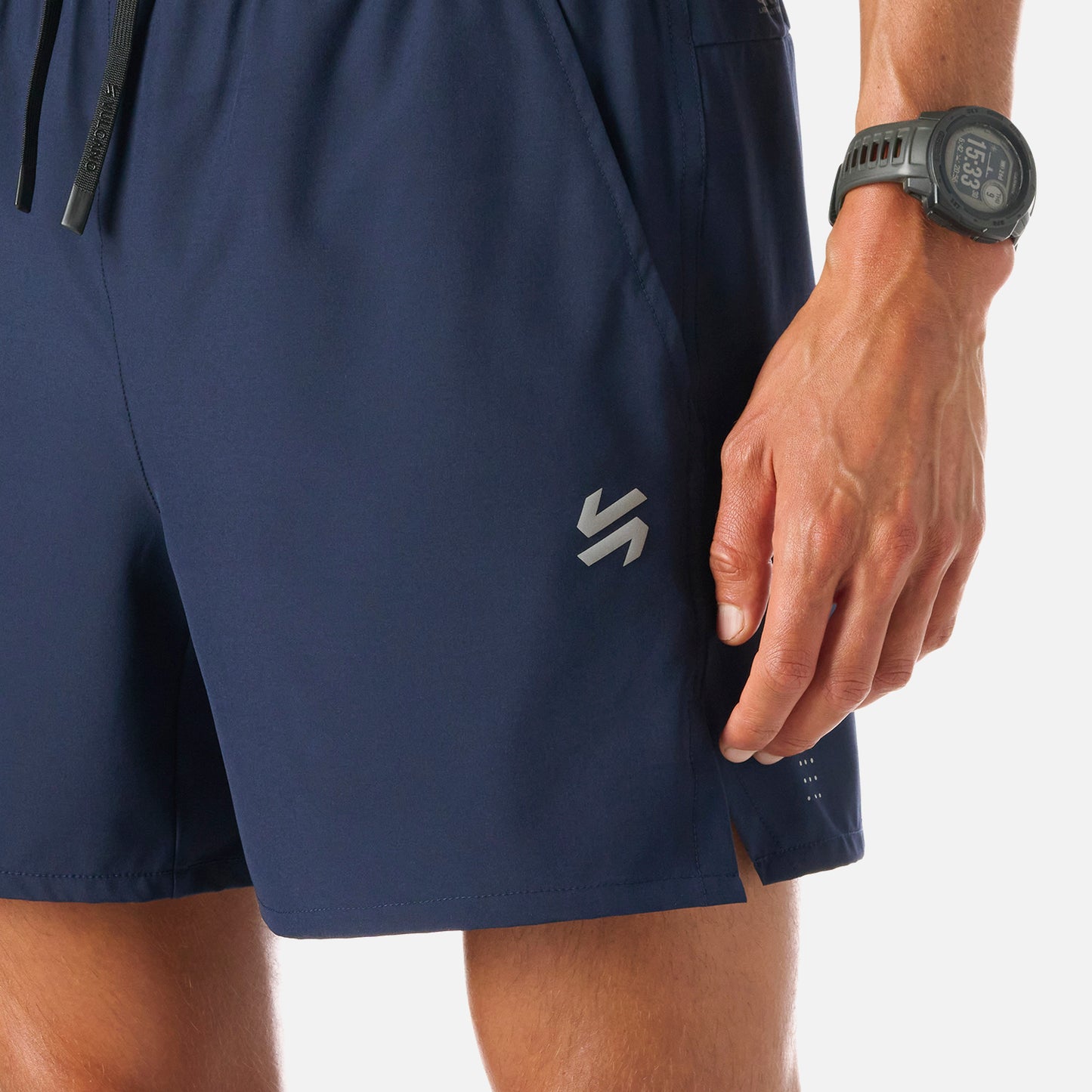 Detalle del logo Vulcano y aberturas laterales en los shorts Tempo 5'' Hombre, con tejido Q-Dry que favorece la transpiración durante el running.