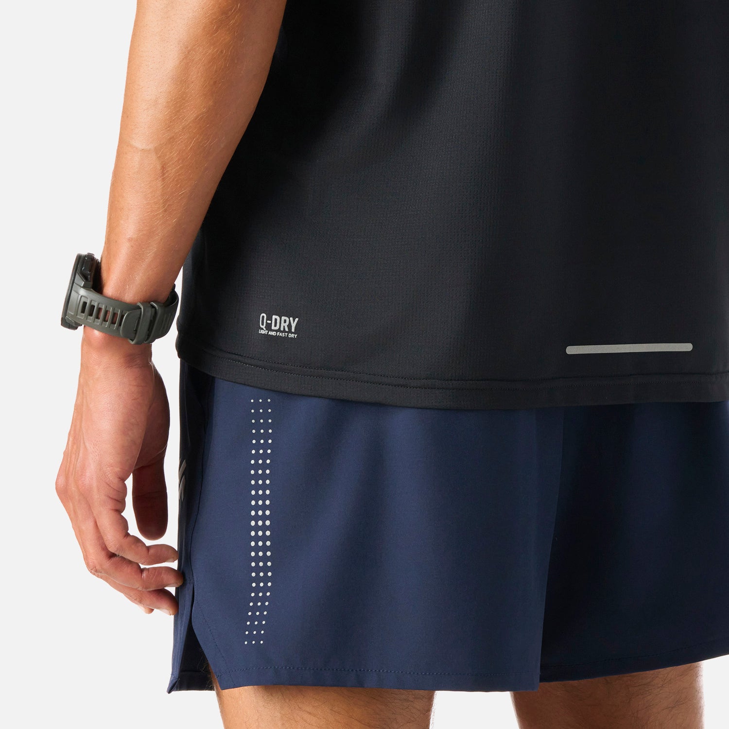Detalle inferior de la Polera Hombre Tempo Advanced T-Shirt Negro Vulcano mostrando tecnología Q-Dry y banda reflectante para mayor visibilidad.