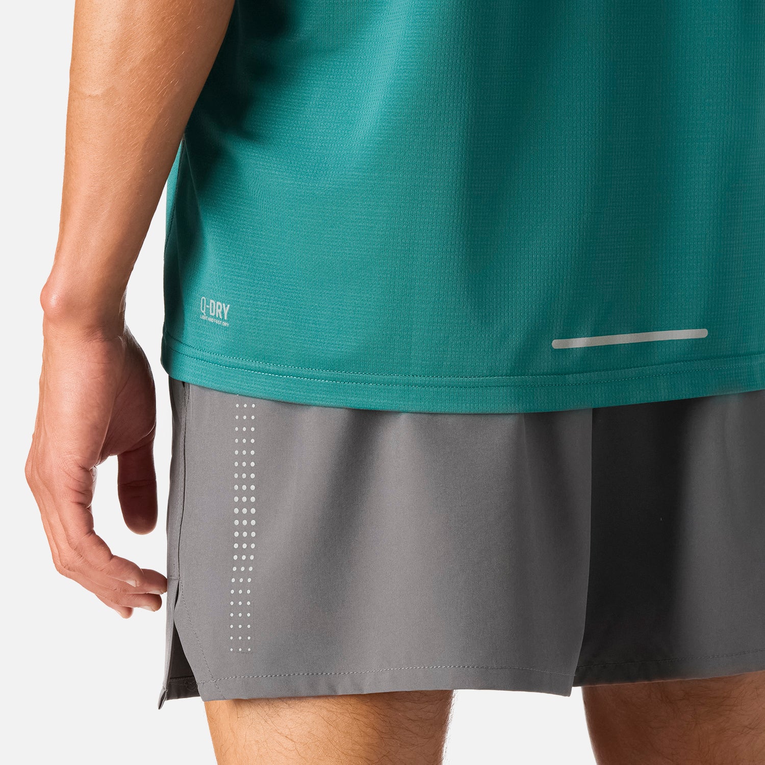 Detalle inferior de la Polera Hombre Tempo Advanced T-Shirt Petroleo Vulcano mostrando tecnología Q-Dry y banda reflectante para mayor visibilidad.