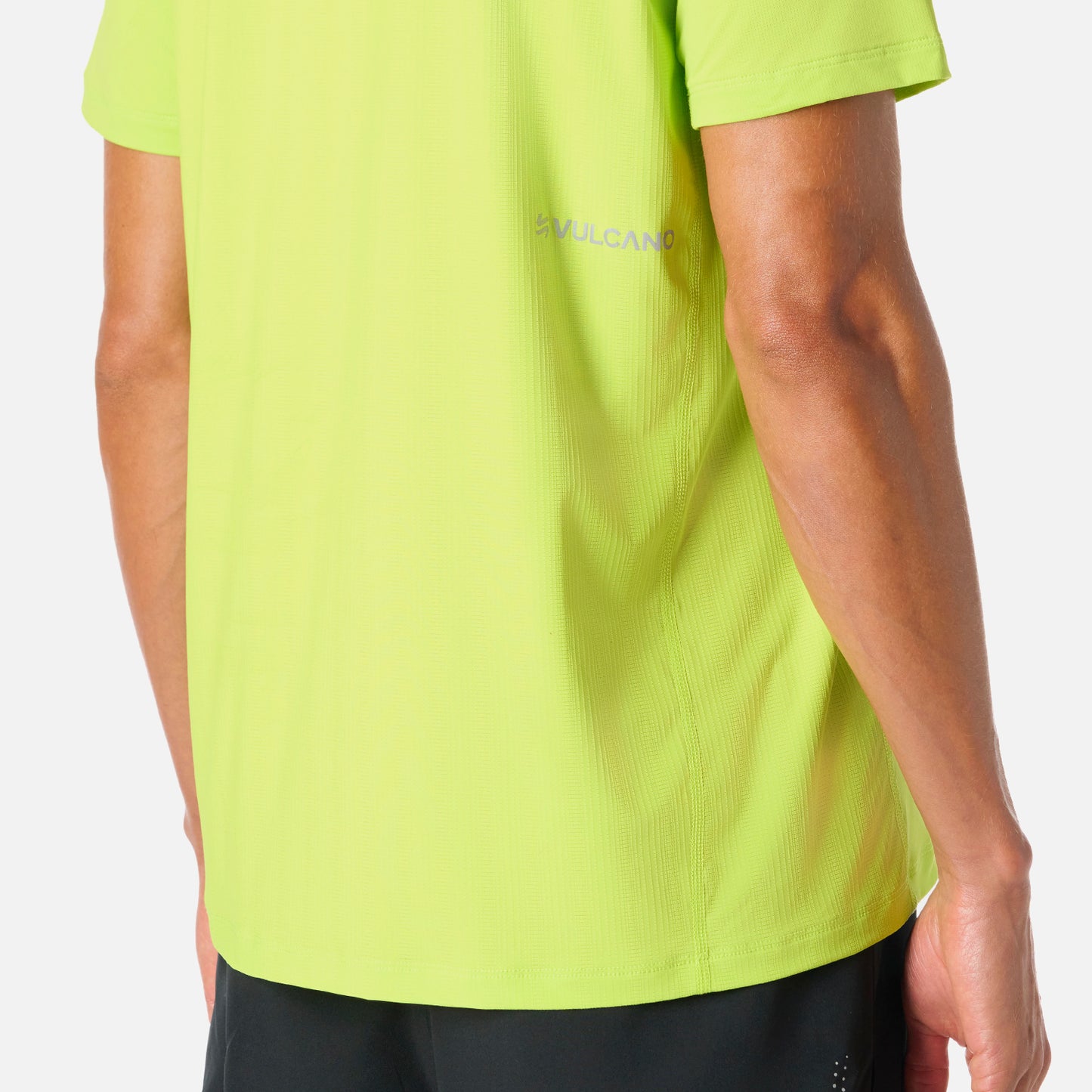 Polera Hombre Verde Lima Vulcano - Deportiva Q-Dry, detalle del logo Vulcano en la espalda. Material técnico ideal para mantener la frescura.
