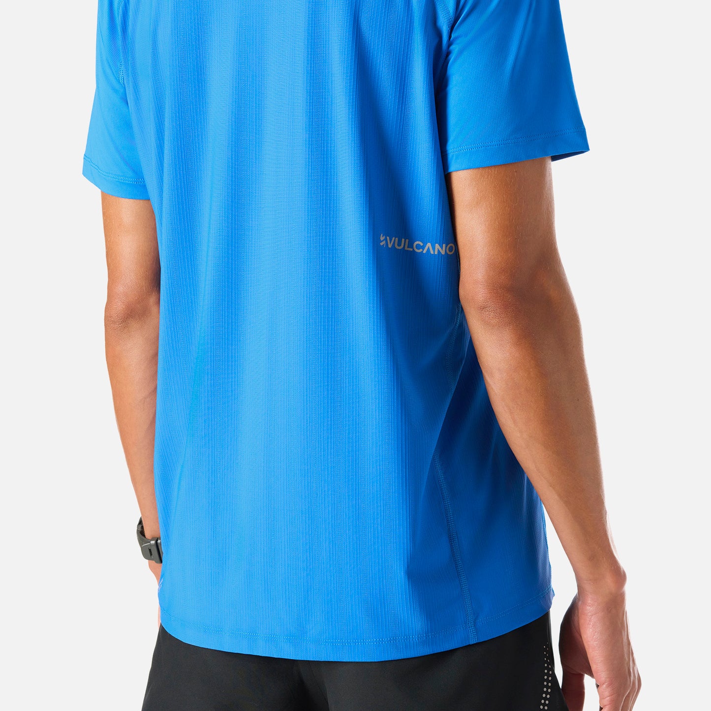 Polera Hombre Azul Vulcano - Deportiva Q-Dry, detalle del logo Vulcano en la espalda. Material técnico ideal para mantener la frescura.