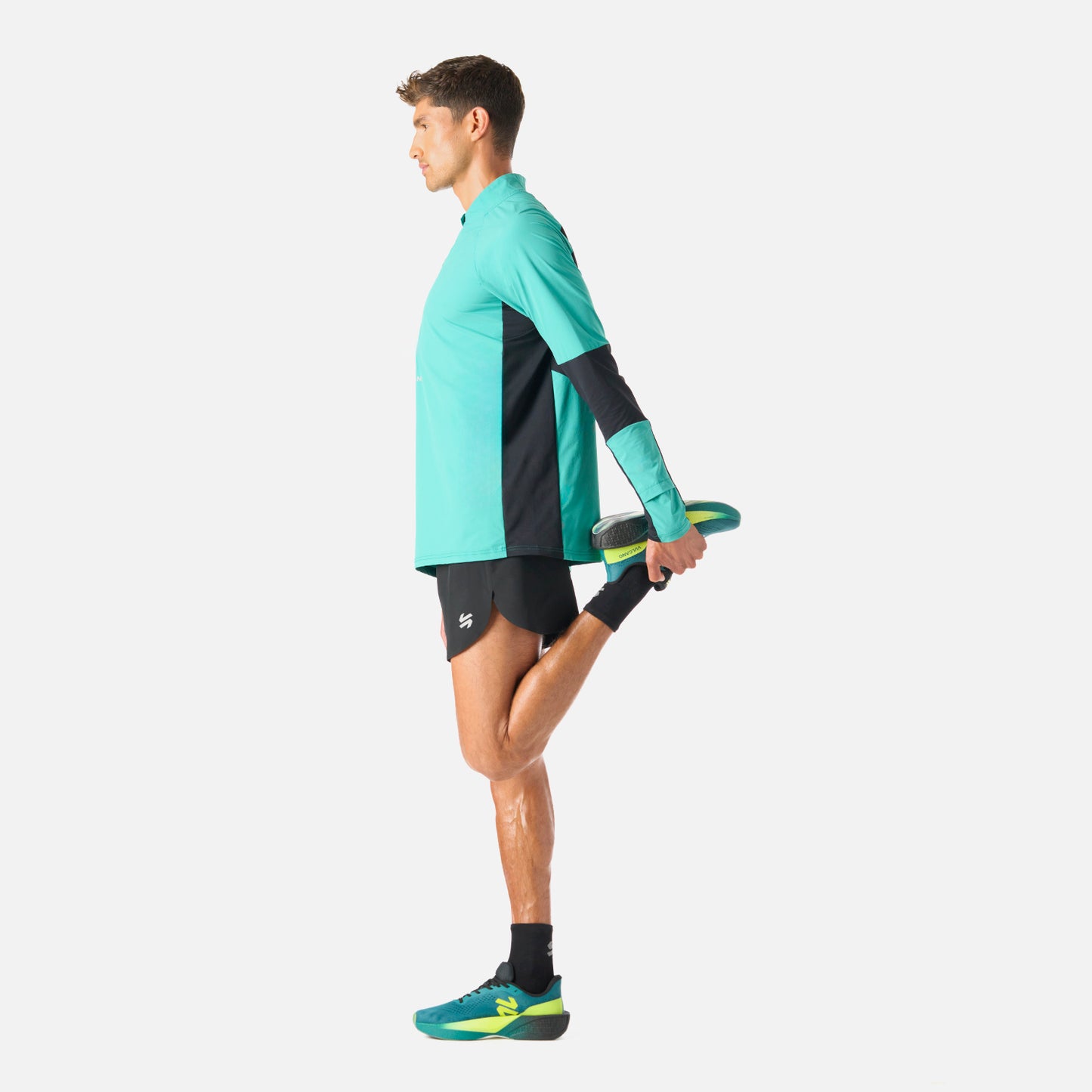 Polerón Hombre Built To Move Pro 1/4 Zip Midlayer Turquesa Vulcano durante rutina de estiramiento, mostrando su flexibilidad y confort.