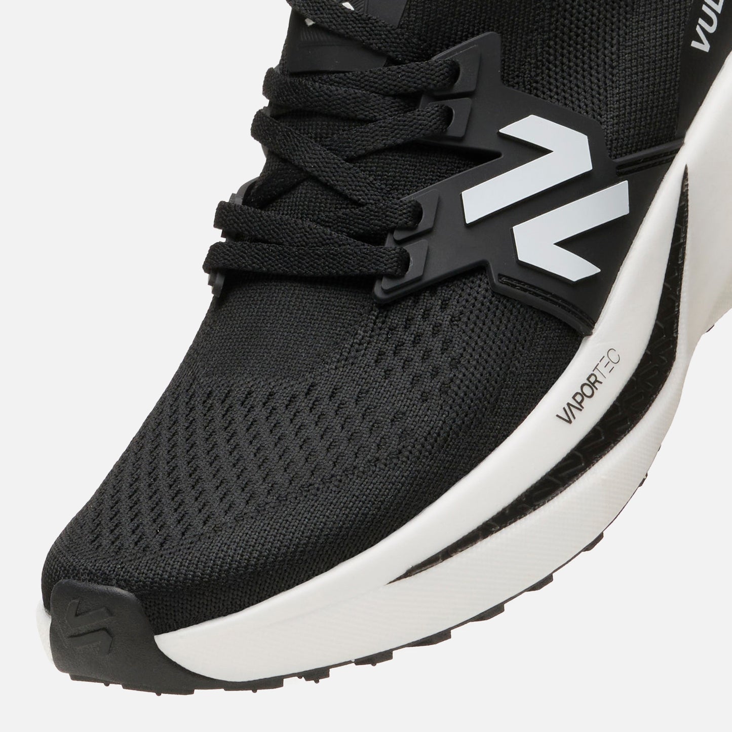 Detalle frontal de las Zapatillas Hombre Magma Negro Vulcano con cordones negros y logo lateral sobre base VaporTec blanca.
