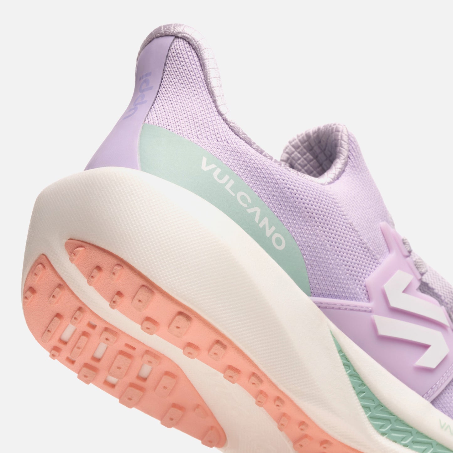 Detalle del talón de las Zapatillas Mujer Magma Lila Vulcano con logo VULCANO y suela coral. Estilo moderno con soporte y amortiguación.