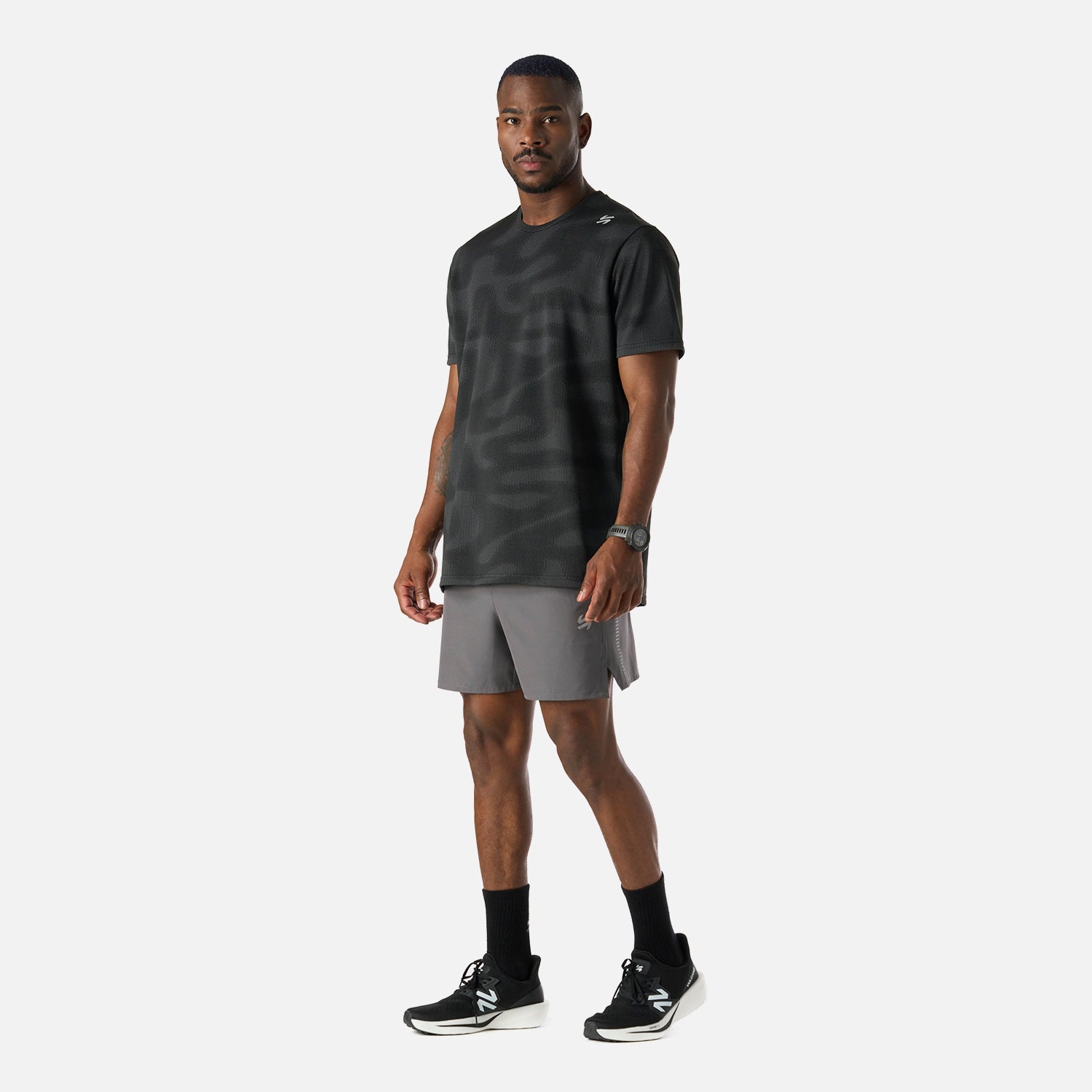 Conjunto deportivo con Polera Hombre Built To Move Pro T-Shirt Negro Vulcano y short azul, ideal para actividades de running y training.
