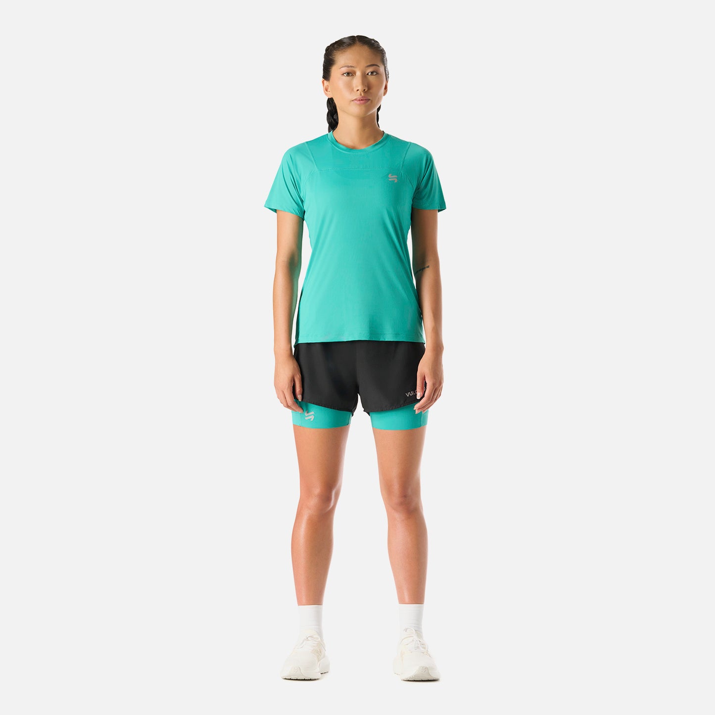 Polera Mujer Built To Move T-Shirt Turquesa Vulcano combinada con short negro, ideal para deportes como running o padel.