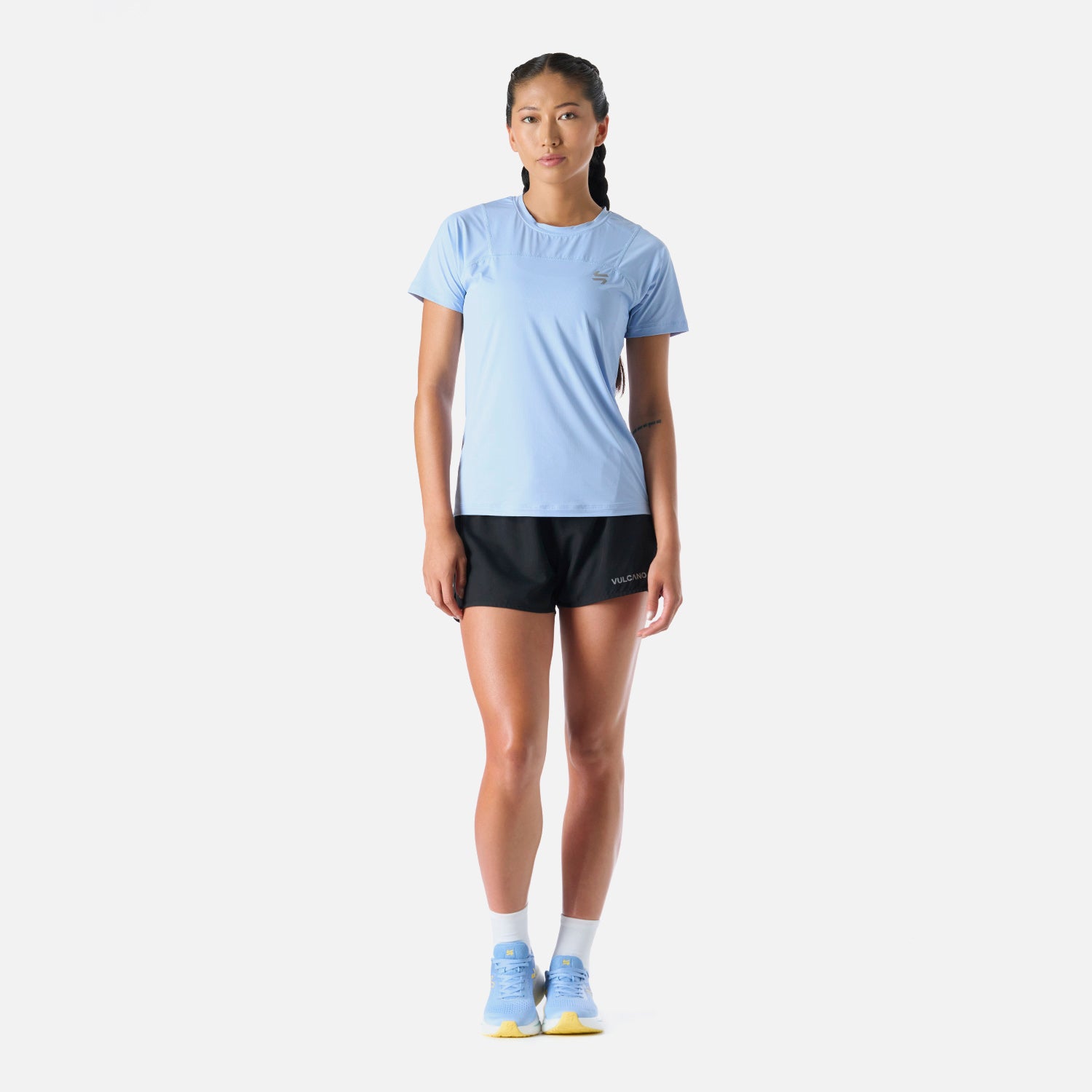 Polera Mujer Built To Move T-Shirt Celeste Vulcano combinada con short negro, ideal para deportes como running o padel.
