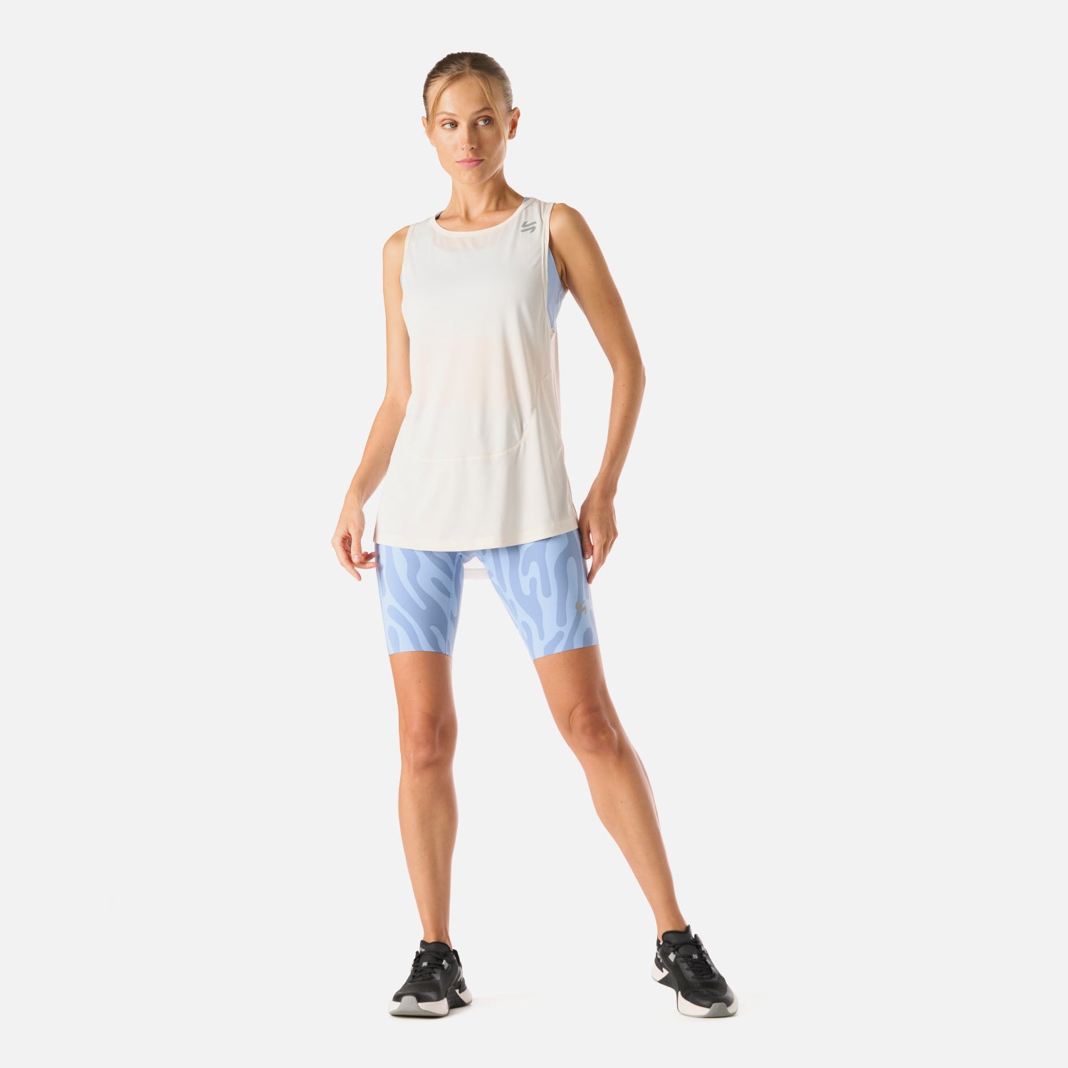 Polera Tempo Tank Top blanca doblada mostrando su corte largo, forma relajada y costuras ergonómicas
