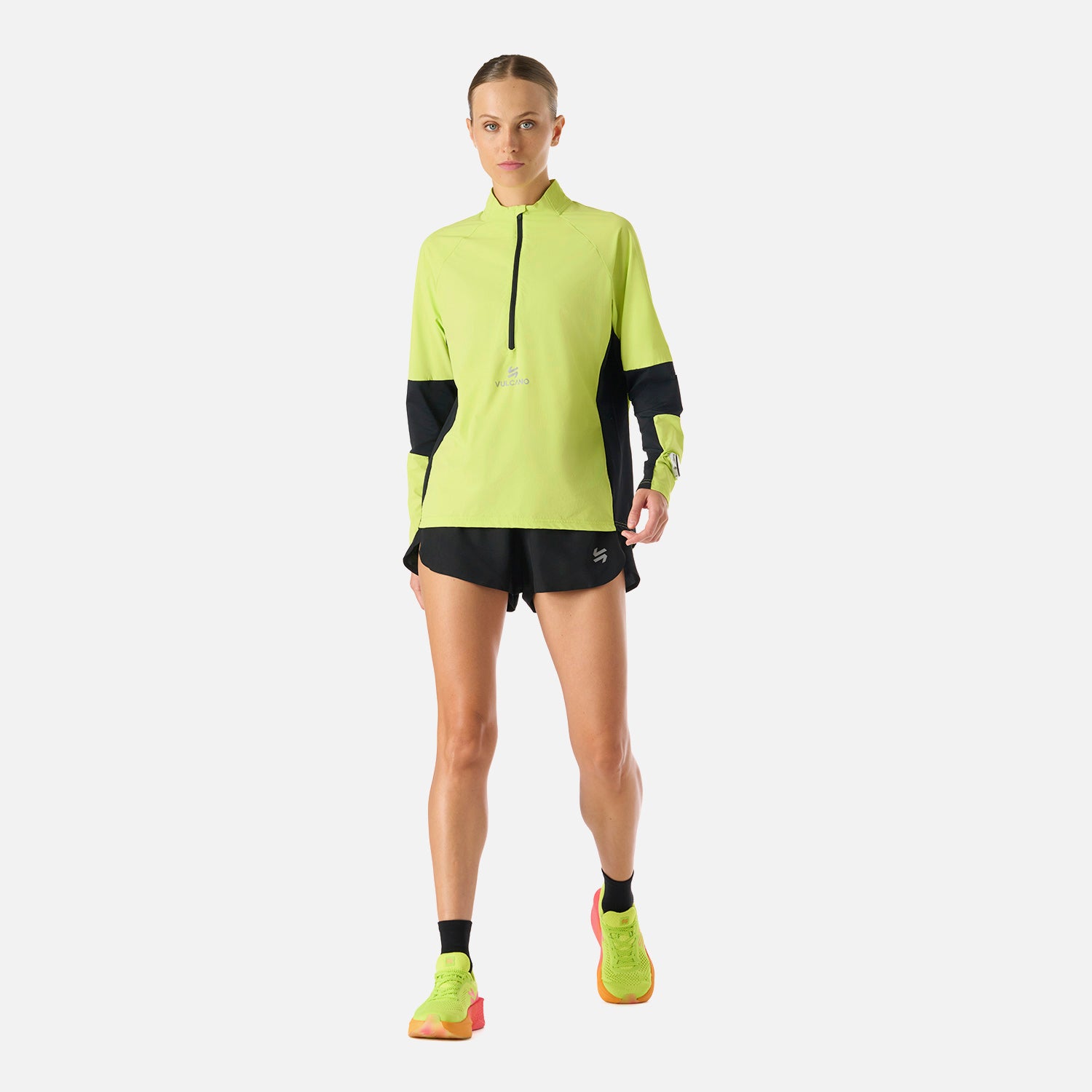 Polerón Mujer Built To Move Pro 1/4 Zip Midlayer Verde Lima Vulcano en acción, mostrando su diseño funcional para running y deportes de invierno.