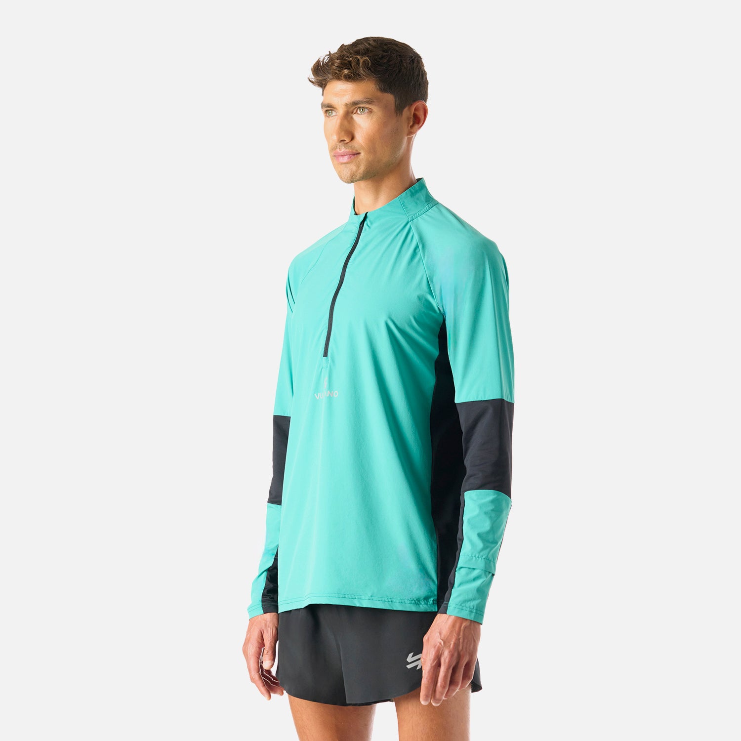 Vista lateral del Polerón Hombre Built To Move Pro 1/4 Zip Midlayer Turquesa Vulcano, diseño ergonómico y tecnología Q-Dry para alto rendimiento.