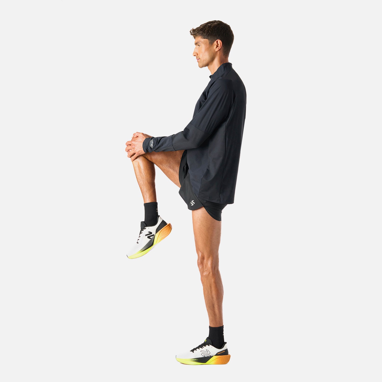 Polerón Hombre Built To Move Pro 1/4 Zip Midlayer Negro Vulcano durante calentamiento, mostrando su flexibilidad y diseño deportivo.