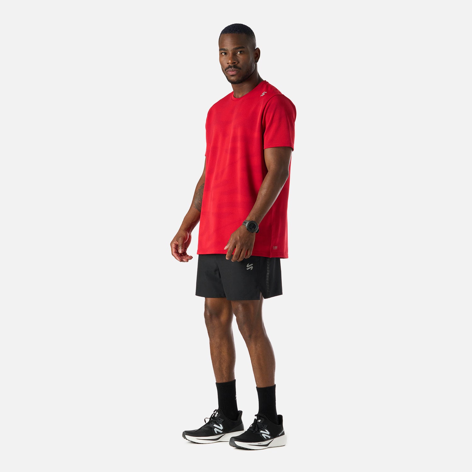 Conjunto deportivo con Polera Hombre Built To Move Pro T-Shirt Anaranjado Vulcano y short negro, ideal para actividades de running y training.