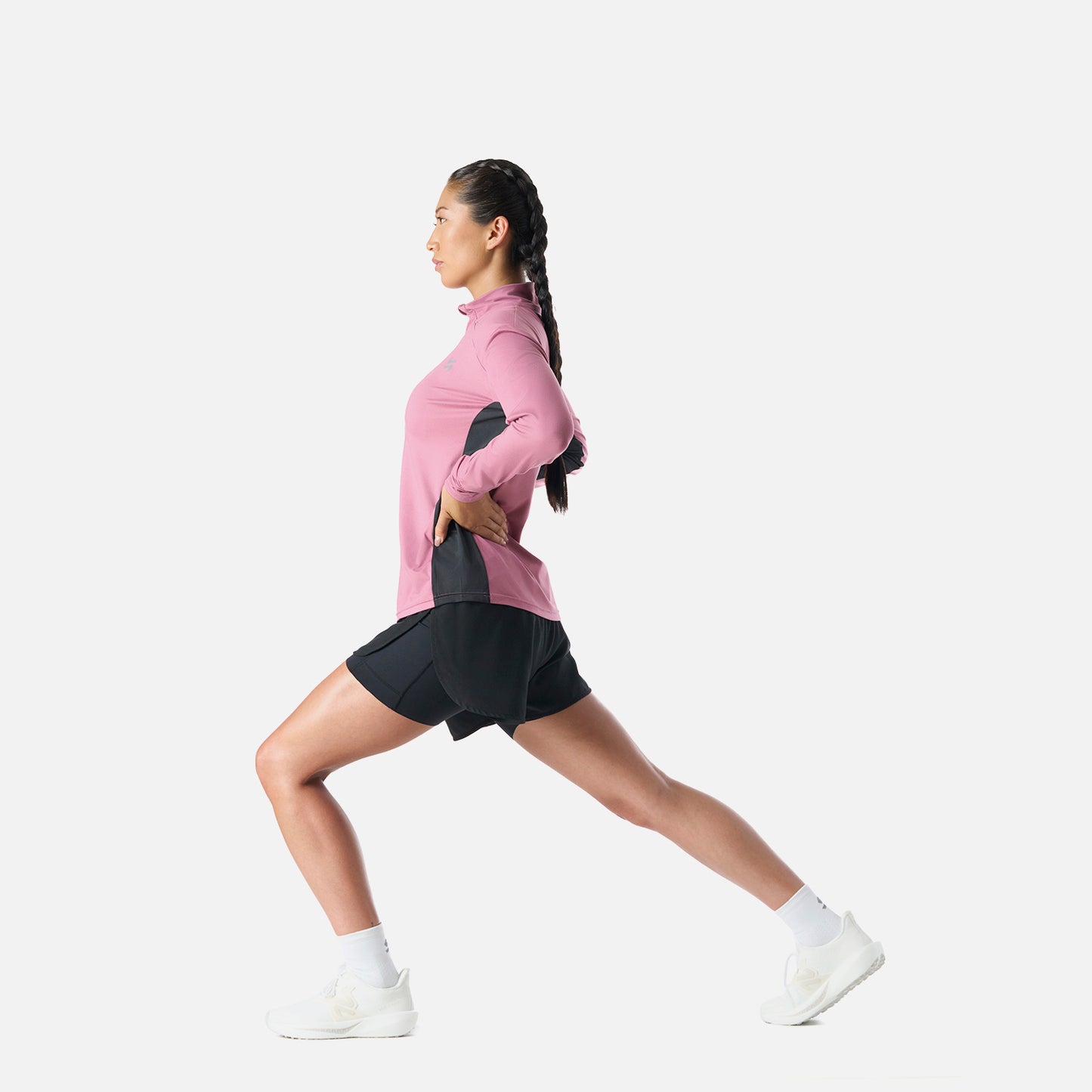 Polerón Mujer Tempo 1/4 Zip Midlayer Rosado Vulcano en uso durante estiramiento, mostrando su funcionalidad para training y running.